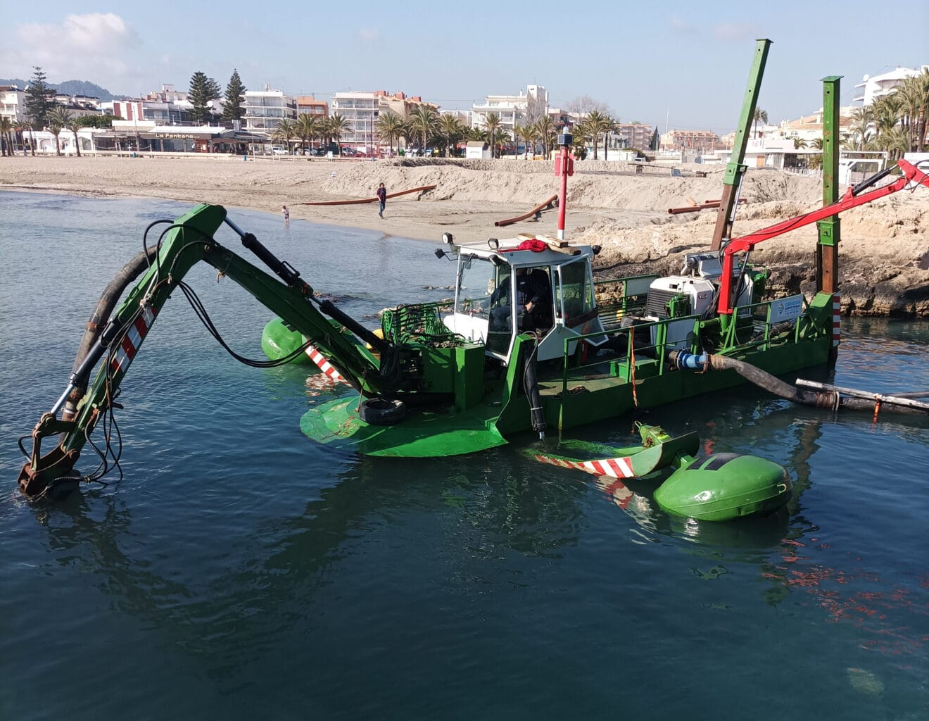 Máquina extrayendo las algas y lodo del canal de la fontana