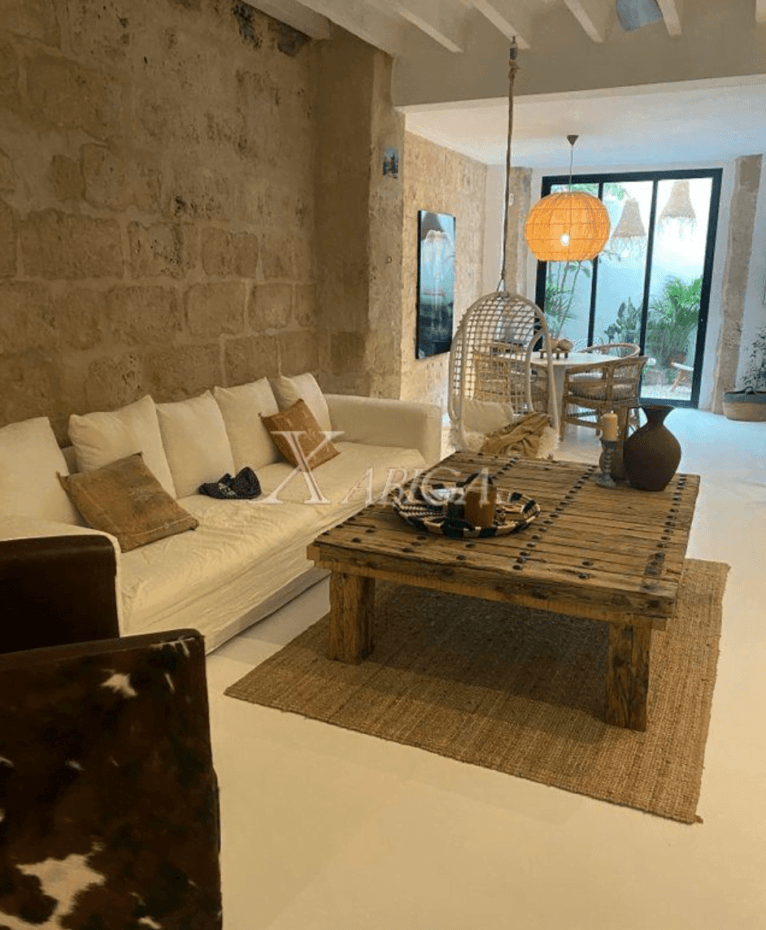 Salón con mesa en el centro de madera, de la casa disponible con Xabiga Inmobiliaria