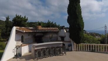 Cocina exterior con barbacoa y barra americana