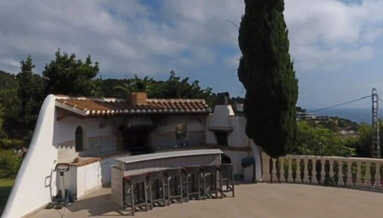 Cocina exterior con barbacoa y barra americana