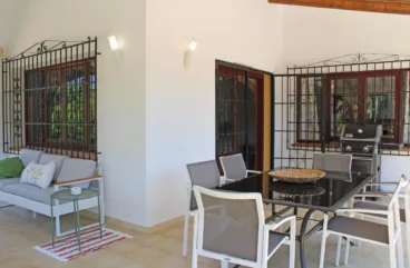 Comedor exterior con barbacoa portatil de esta villa en alquiler