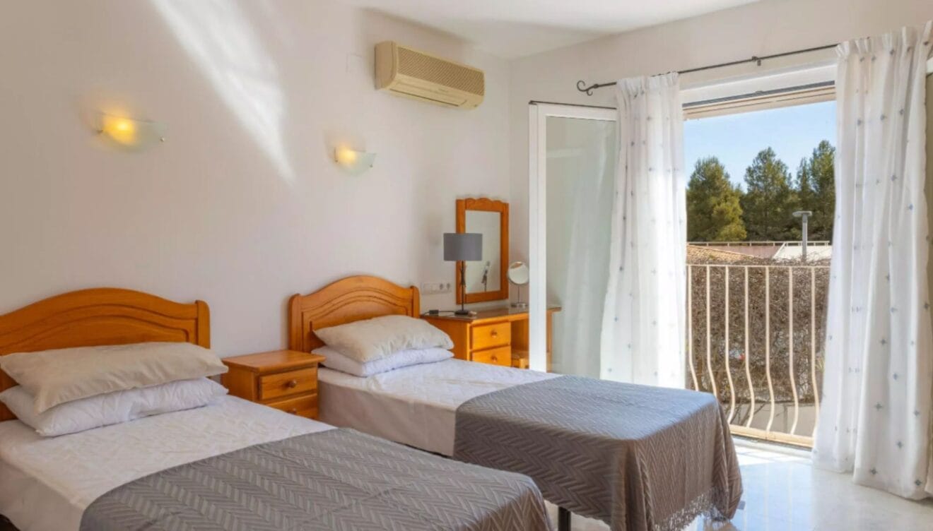 Dormitorio con dos camas y aire acondicionado