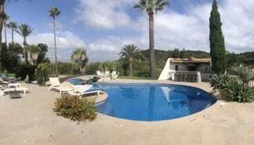 Gran piscina con tumbonas y zona de barbacoa