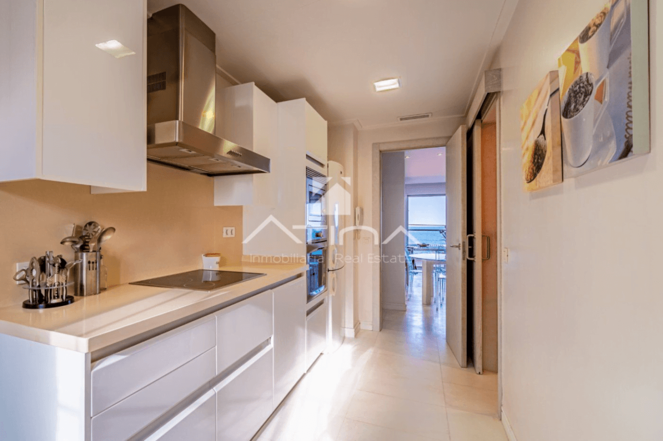 Cocina bien equipada con mobiliario en blanco