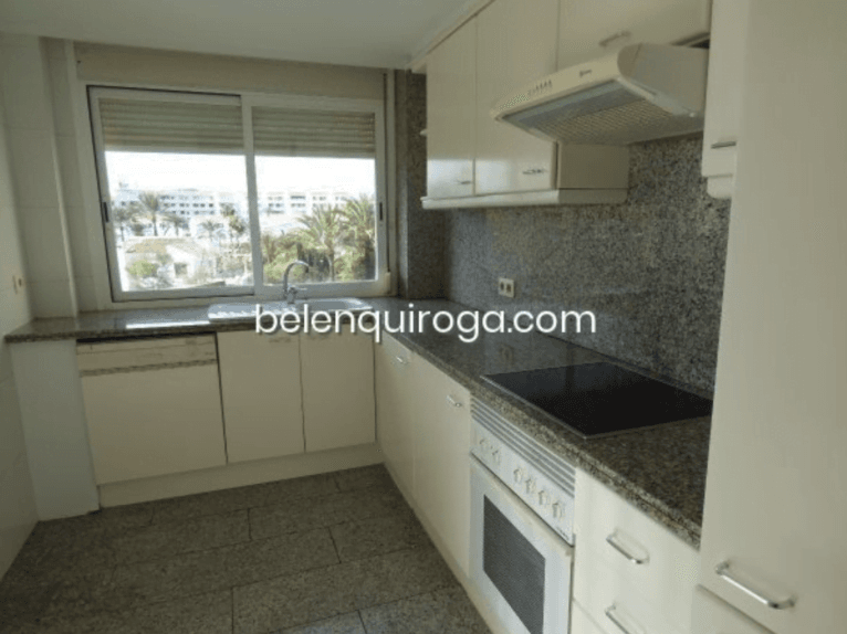 Cocina equipada con armarios en blanco y granito