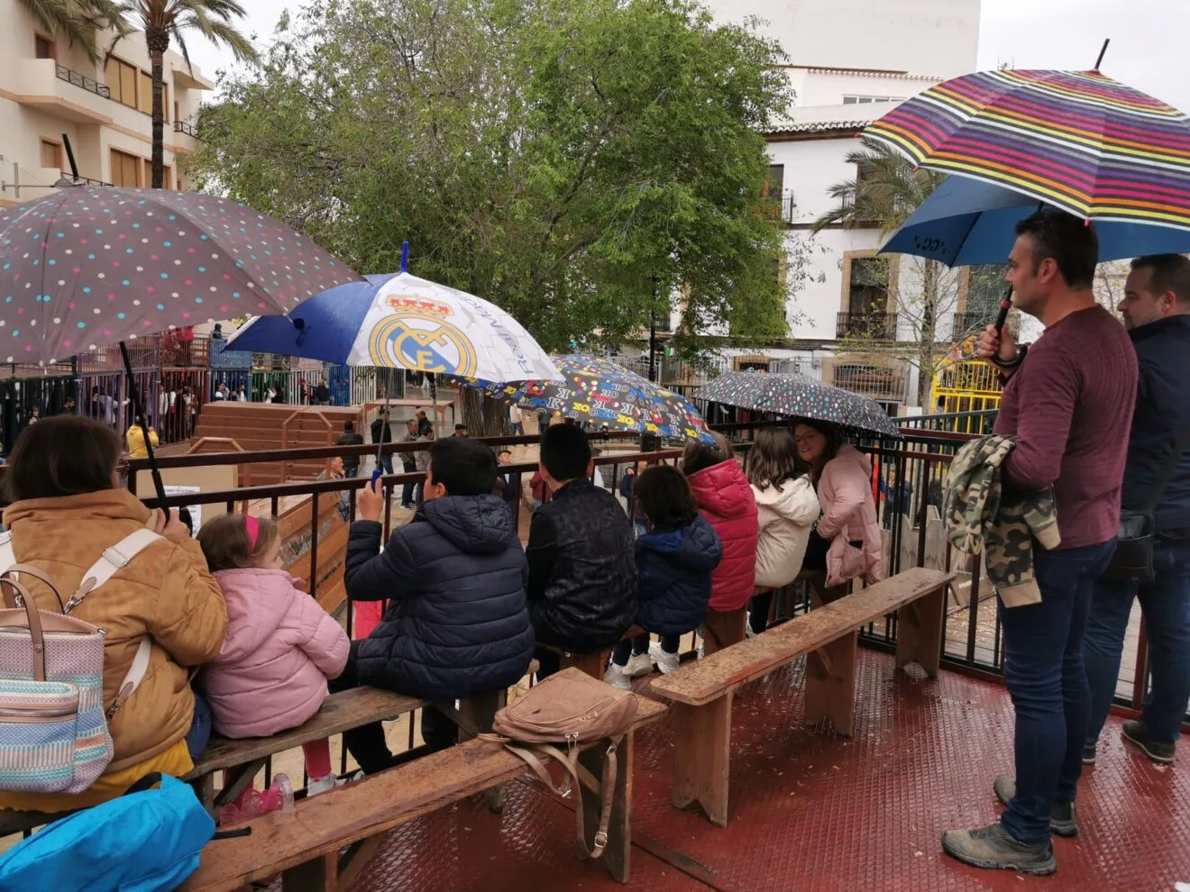 Personas bajo los paraguas disfrutando de la sesión taurina