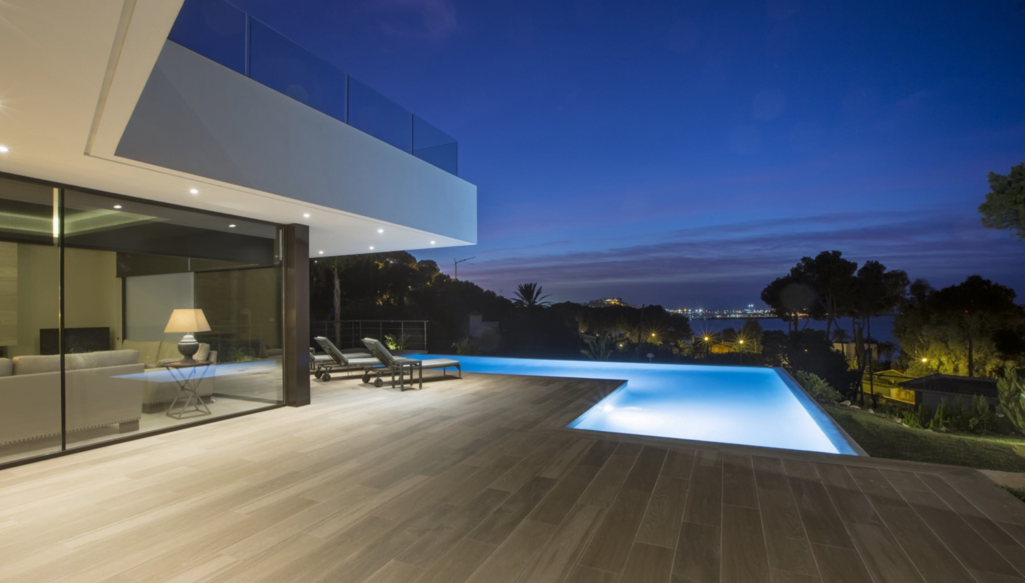 Terraza con piscina iluminada de noche – Urbimed Villas