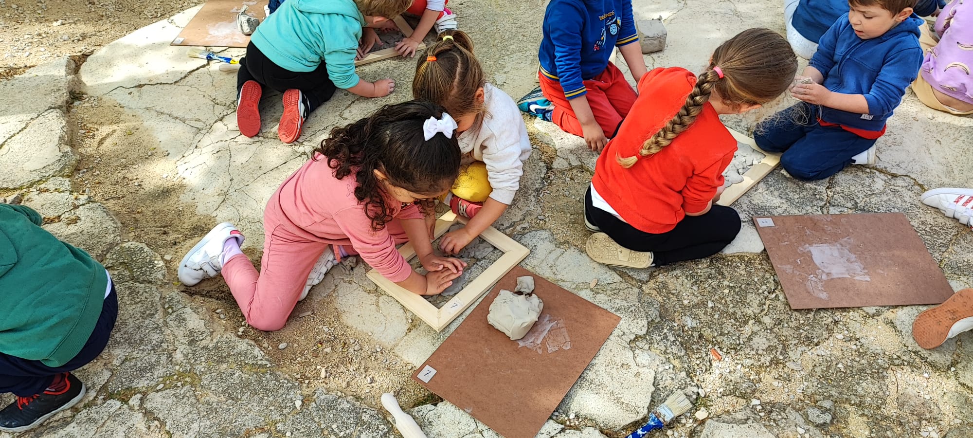 Alumnos de infantil elaborando las bases de arcilla
