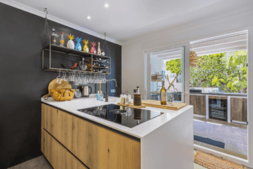 Cocina interior junto a la cocina exterior, con isla en el centro