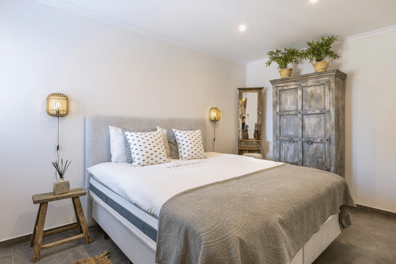 Dormitorio de estilo rústico con cama de matrimonio