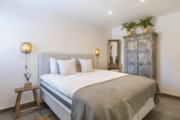 Dormitorio de estilo rústico con cama de matrimonio