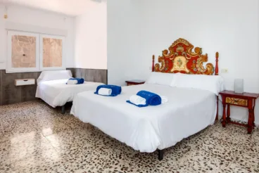 Dormitorio de la vivienda de estilo rústico con varias camas