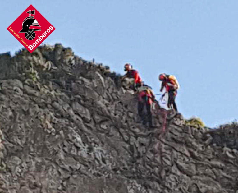 O grupo de bombeiros resgatando o alpinista