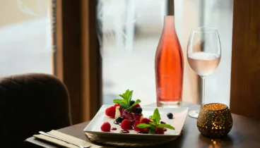 Postre de tarta de queso y vino rosado