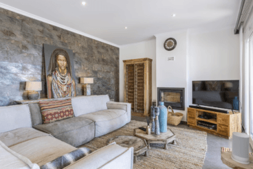 Salón de la vivienda con gran sofá y chimenea