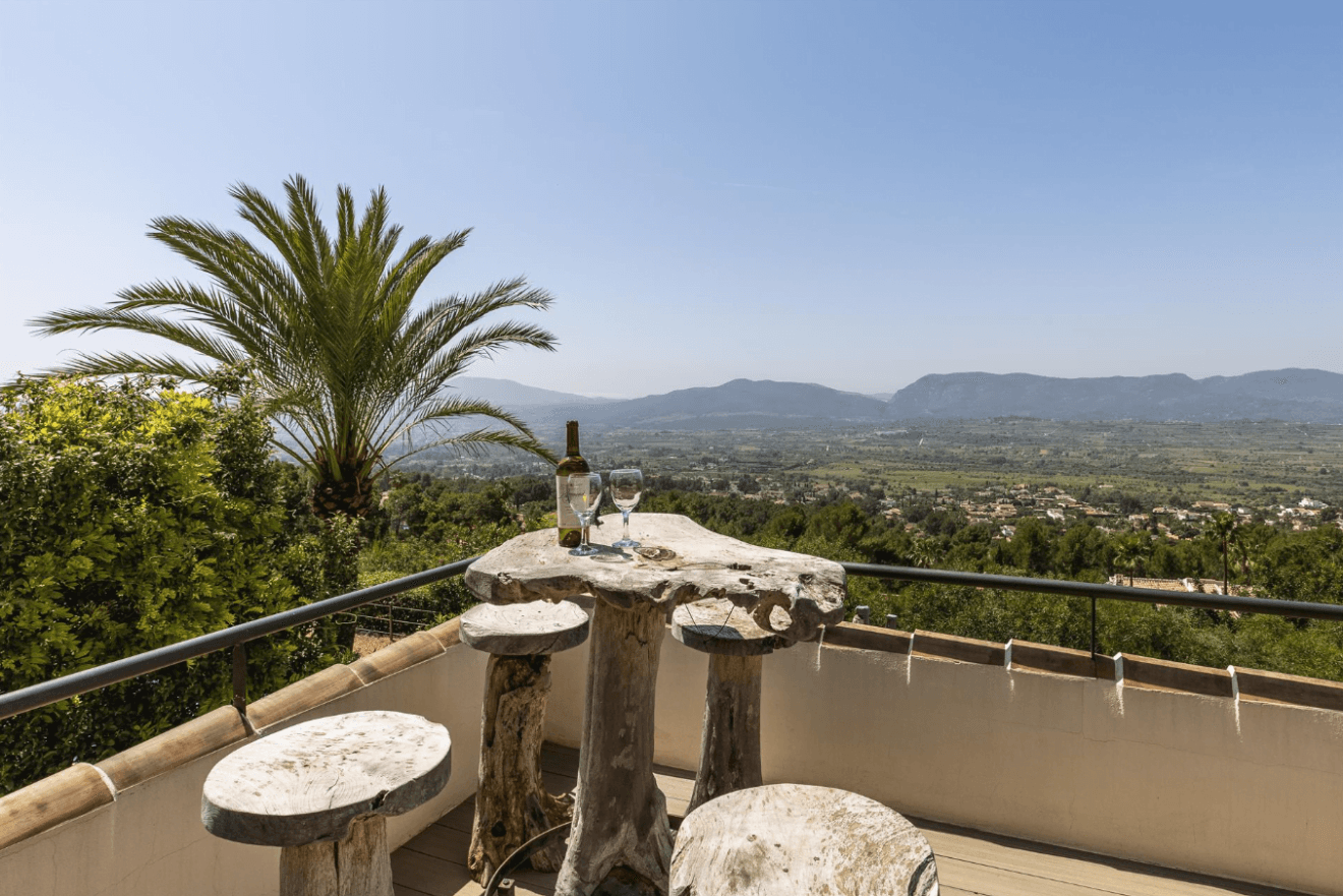 Terraza exterior con un original mueble de madera