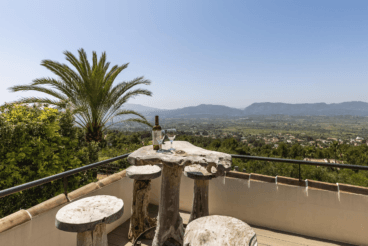 Terraza exterior con un original mueble de madera