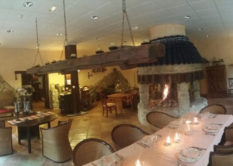 Zona de comedor con chimenea de piedra en el centro