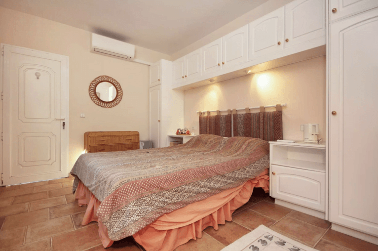 Dormitorio con cama de matrimonio de estilo étnico con mucho espacio de almacenaje