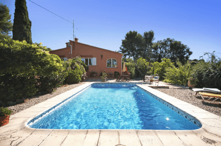 Piscina de la vivienda con zona para tomar el sol