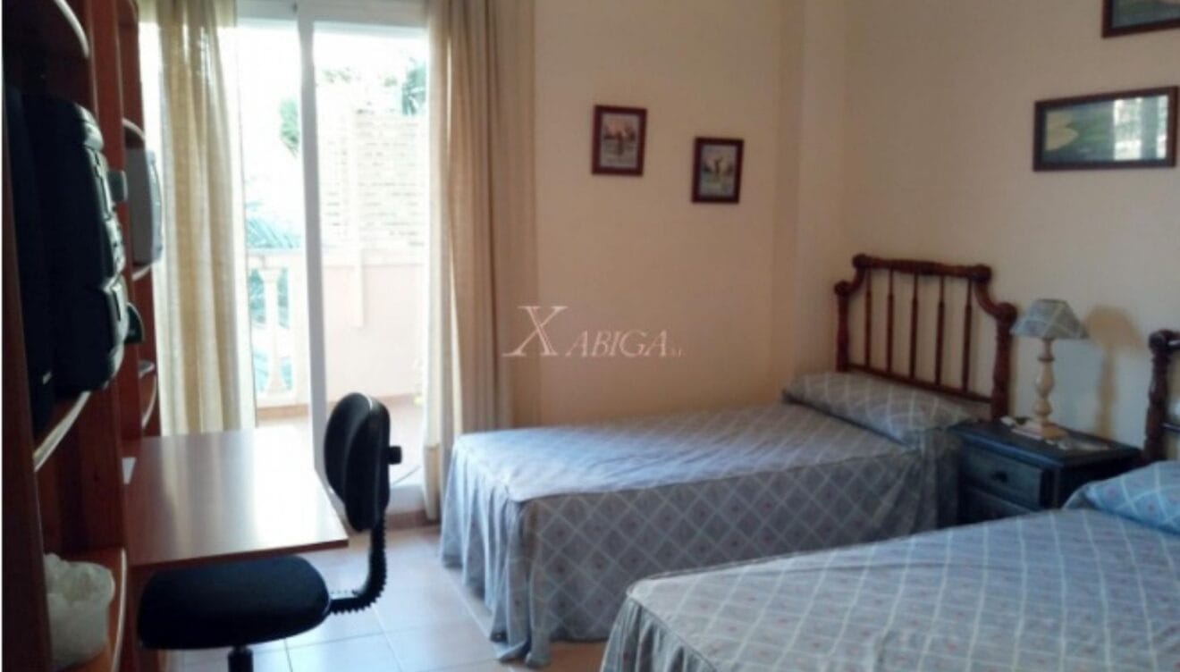 Dormitorio doble con dos camas individuales y acceso a balcón