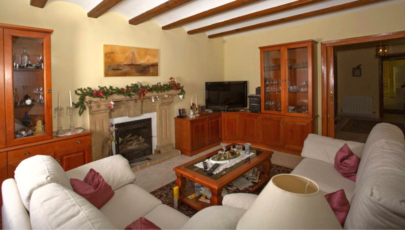 Salón estilo rústico equipado con dos sofás color crema junto a la chimenea