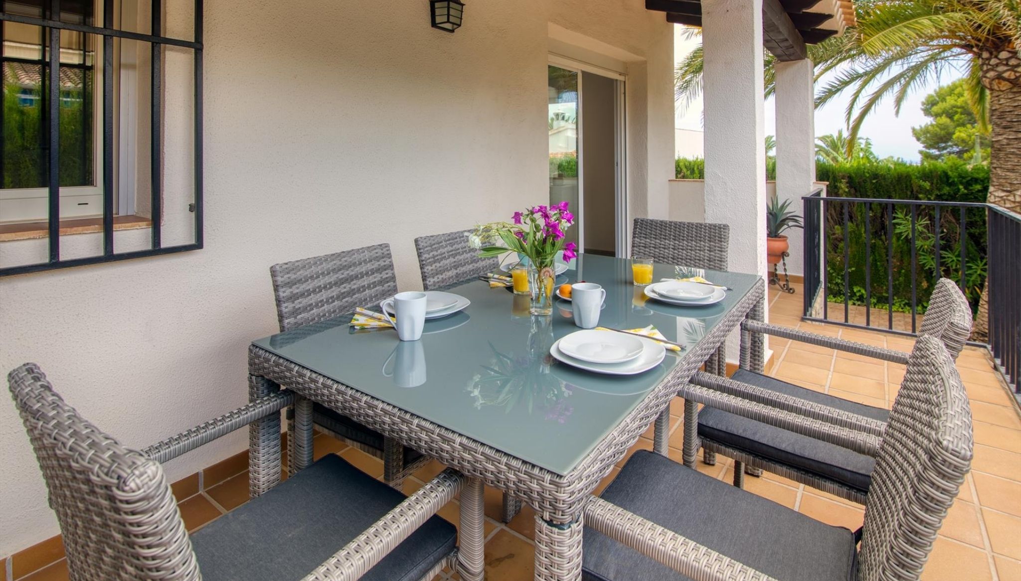 Terraza cubierta con mesa y sillas para comer