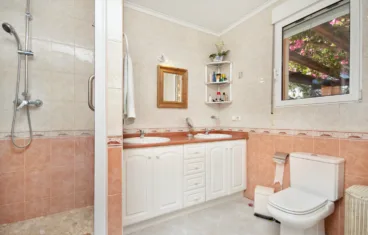 Baño en suite equipado con dos lavabos y ducha