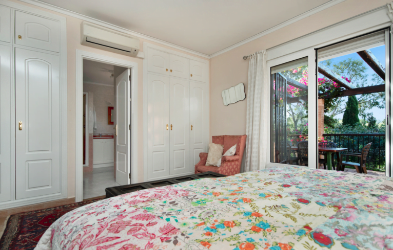 Dormitorio con armarios empotrados, aire acondicionado y baño en suite