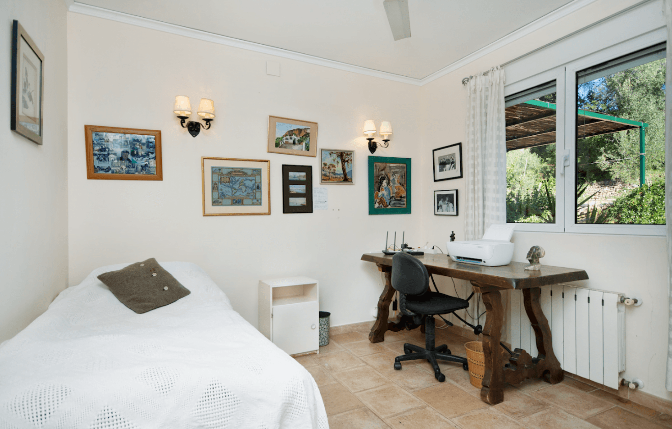 Dormitorio con cama individual y escritorio