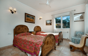 Dormitorio de estilo rústico-clásico con dos camas individuales