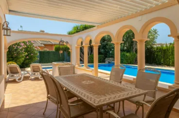 Zona de comedor exterior cubierto por una pérgola