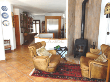 Zona de estar con dos sillones de piel y chimenea