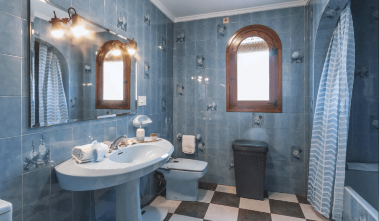 Baño equipado con bañera y alicatado en azul