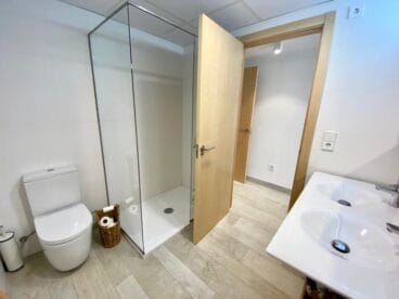 Baño equipado con dos lavabos y un plato de ducha con mampara