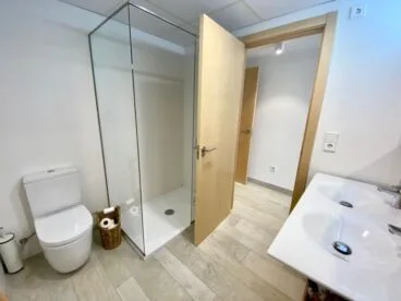 Baño equipado con dos lavabos y un plato de ducha con mampara