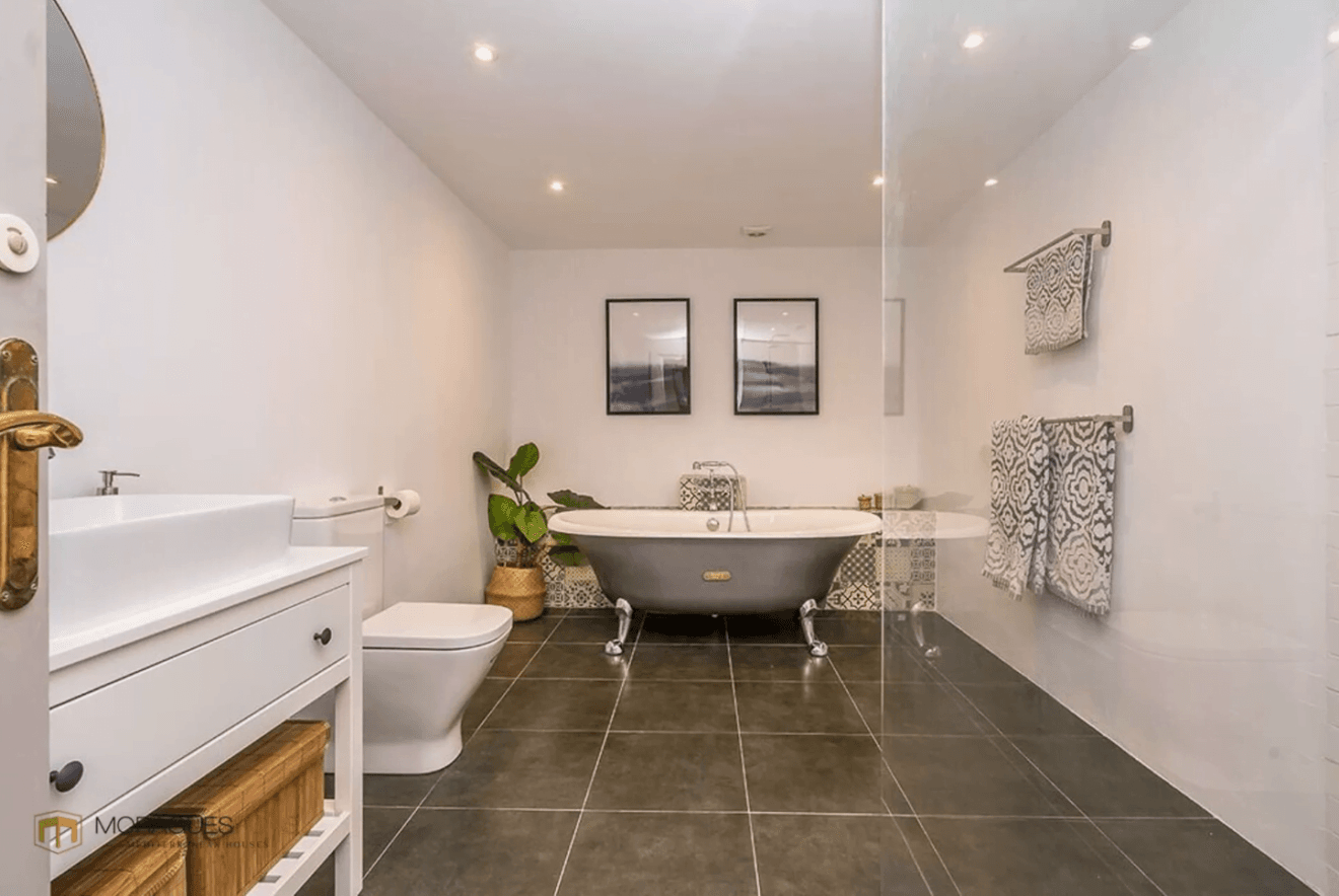 Moderno baño en suite con bañera de patas