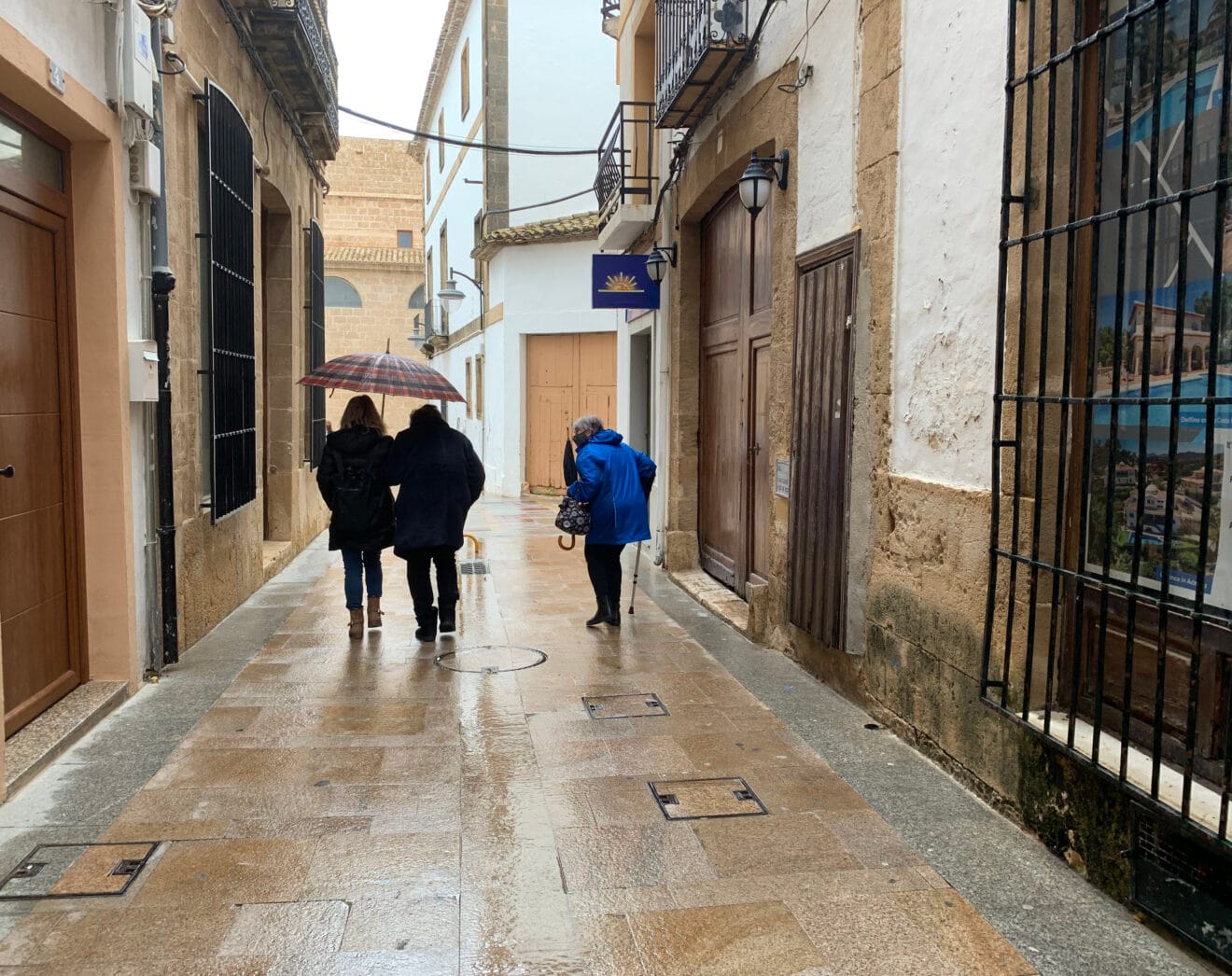 Personas con paraguas en el centro histórico de Xàbia