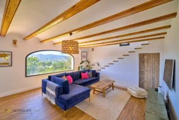 Zona del salón con escaleras a la planta superior