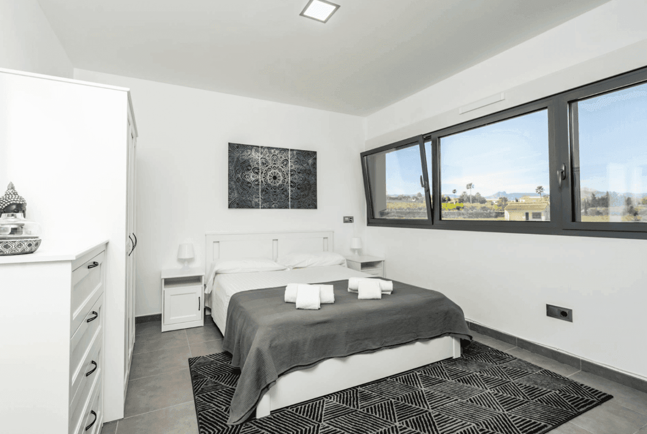Dormitorio muy luminoso con un gran ventanal