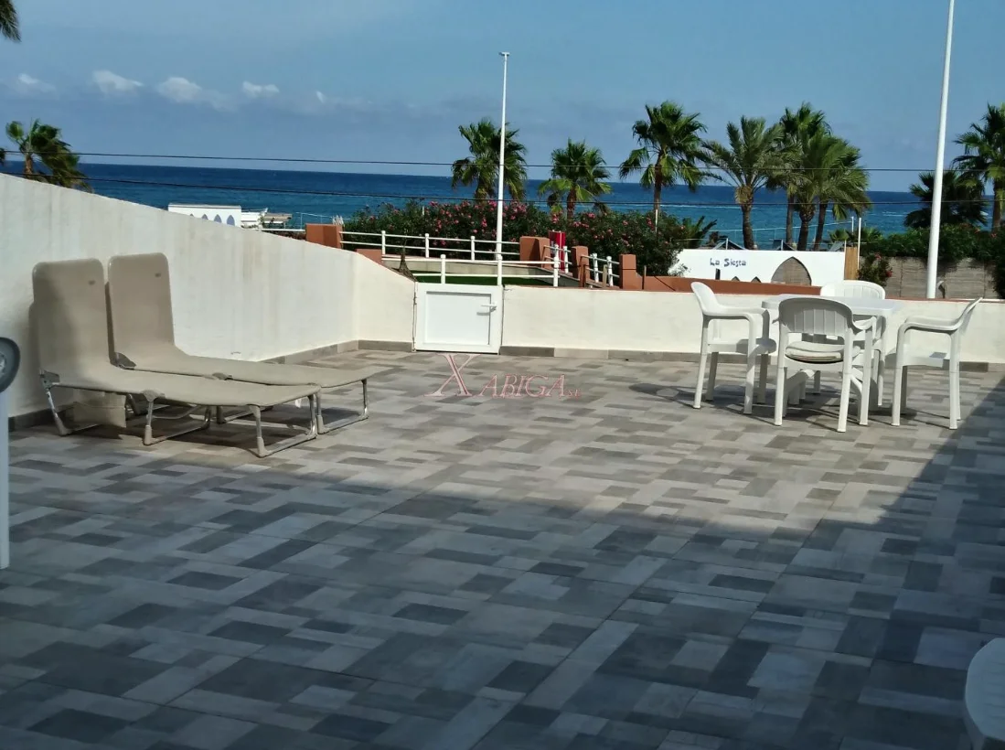 Terraza de la vivienda con vistas al mar y conjunto de comedor exterior