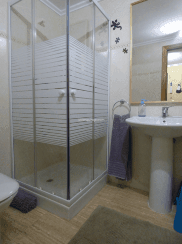 Baño de la vivienda con plato de ducha y mampara