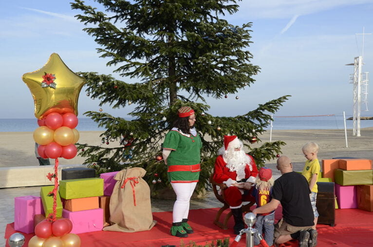 Papá Noel conversa con los niños en la playa del Arenal