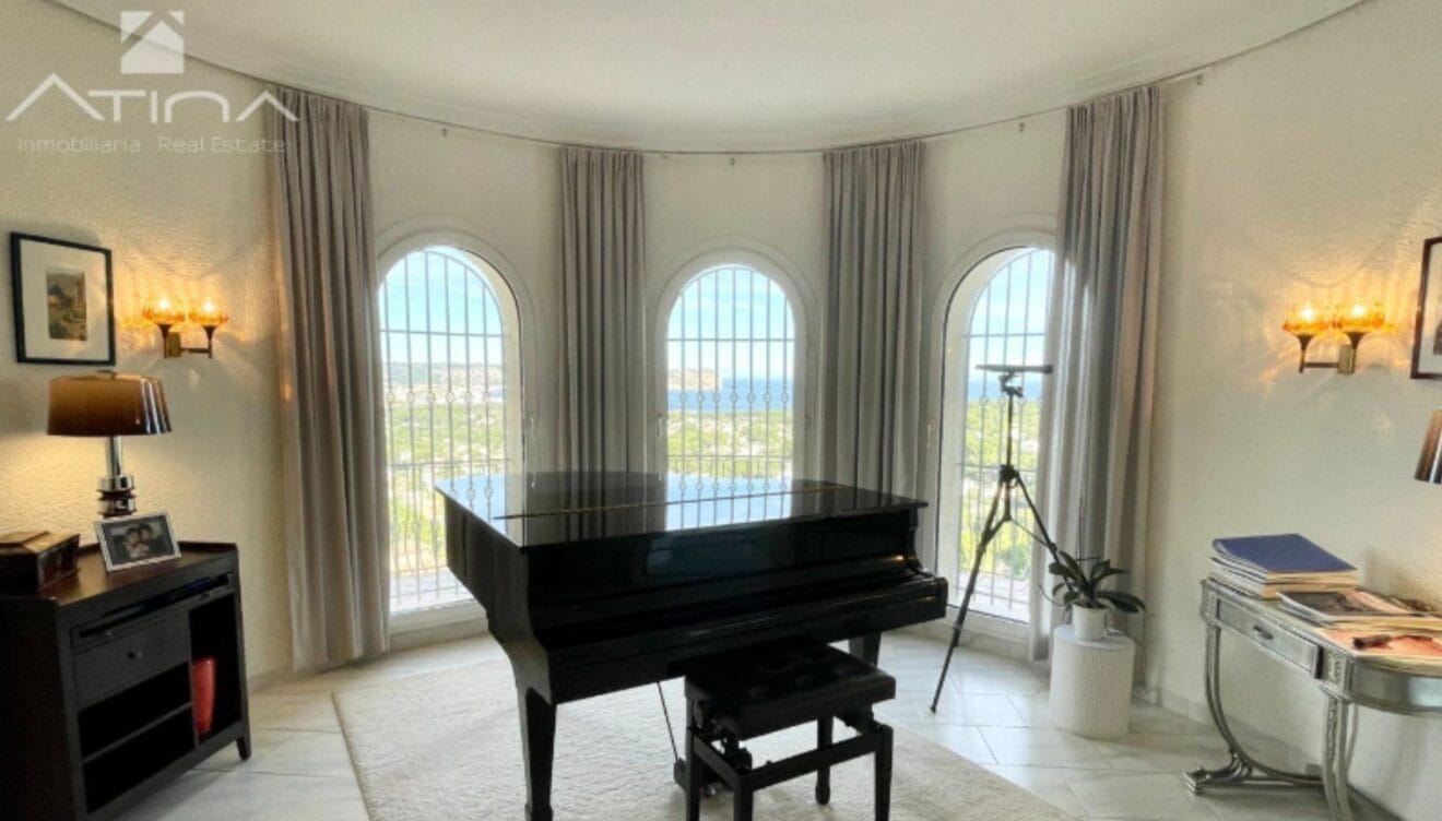 Zona del salón con piano de cola y vistas al mar