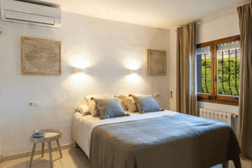 Dormitorio con cama de matrimonio y aire acondicionado