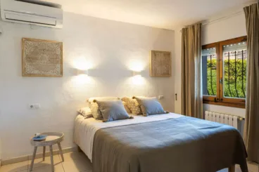 Dormitorio con cama de matrimonio y aire acondicionado