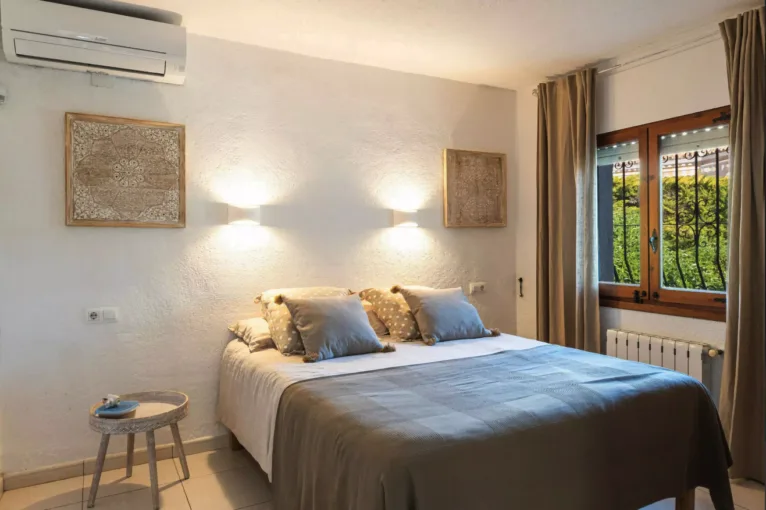 Dormitorio con cama de matrimonio y aire acondicionado