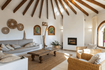 Salón de la villa, con chinenea y techo con bigas de madera