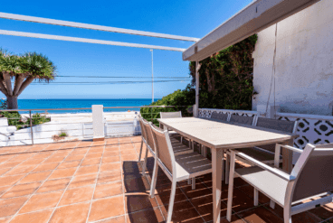 Terraza de la vivienda con toldo y conjunto de comedor exterior