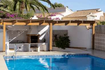 Zona de barbacoa exterior cubierta con una pérgola